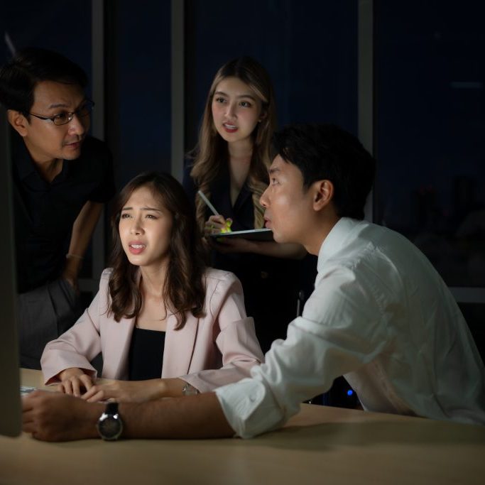 Group of business people working in office at night. Business concept.